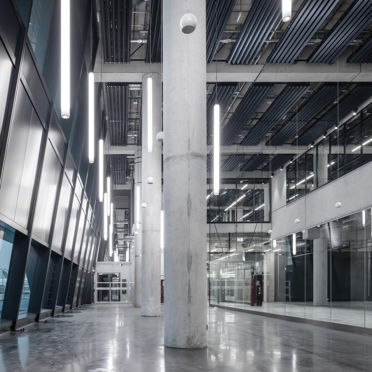 Pier G Terminal 3 Flughafen Frankfurt mit Y-Lamellen Heiz- und Kühldecke von Lindner, schräger Glasfassade und modernen Glastrennwänden im offenen Terminalbereich.