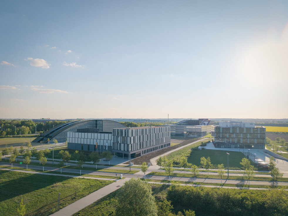 © © www.Lindner-Group.com Drohnenaufnahme des DLR-Institutsgebäudes im Technologiepark Augsburg mit modernen Forschungs- und Büroflächen, umgeben von begrünten Außenanlagen unter sonnigem Himmel | © © www.Lindner-Group.com