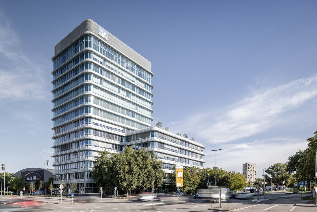 Außenansicht des Donau Towers in Ingolstadt – schlanke Glas‑ und Stahlfassade, leuchtende Fensterfront und markanter Turm, das von Lindner gestaltete Gebäude von außen betrachtet | © © www.Lindner-Group.com