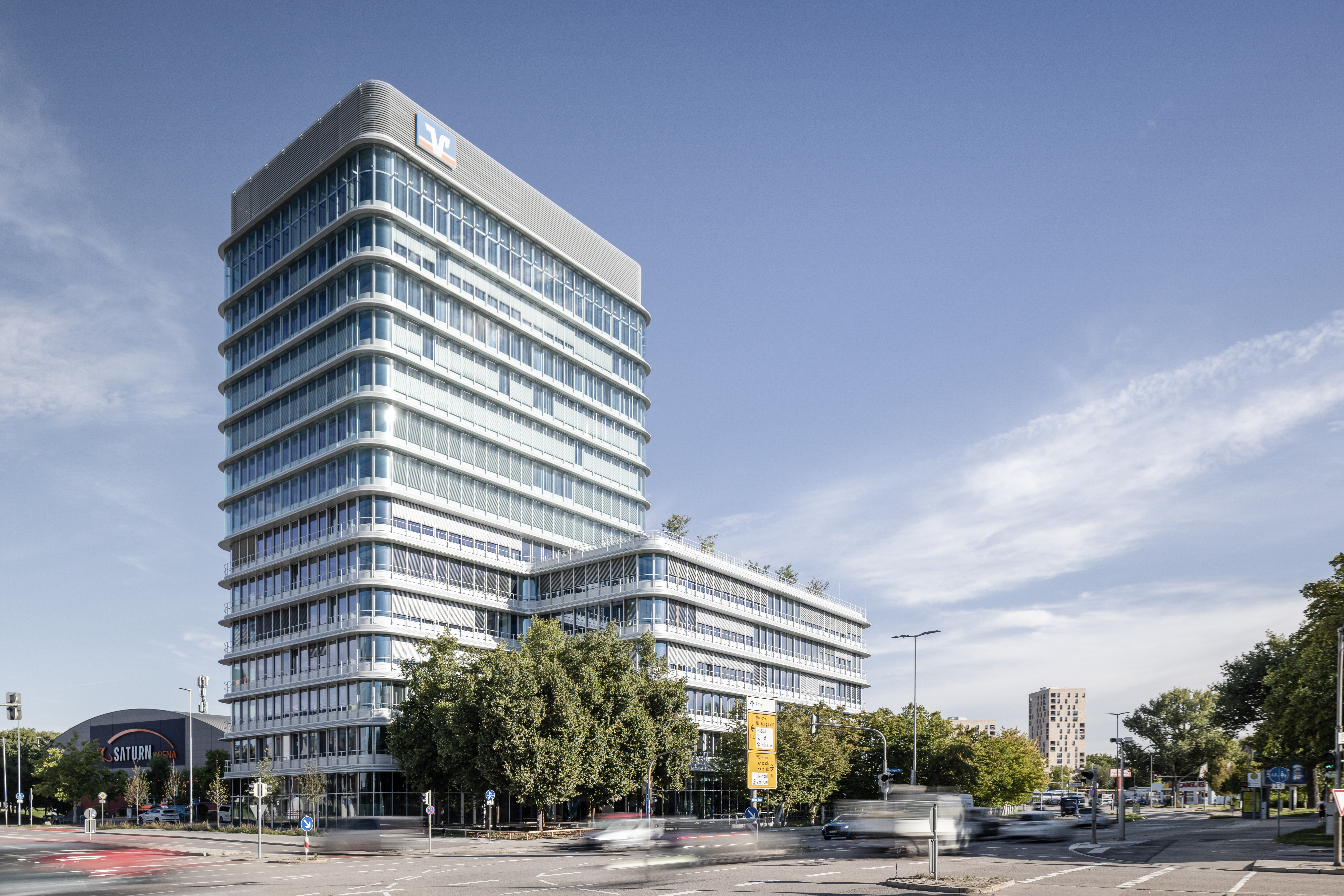 Außenansicht des Donau Towers in Ingolstadt – schlanke Glas‑ und Stahlfassade, leuchtende Fensterfront und markanter Turm, das von Lindner gestaltete Gebäude von außen betrachtet | © © www.Lindner-Group.com