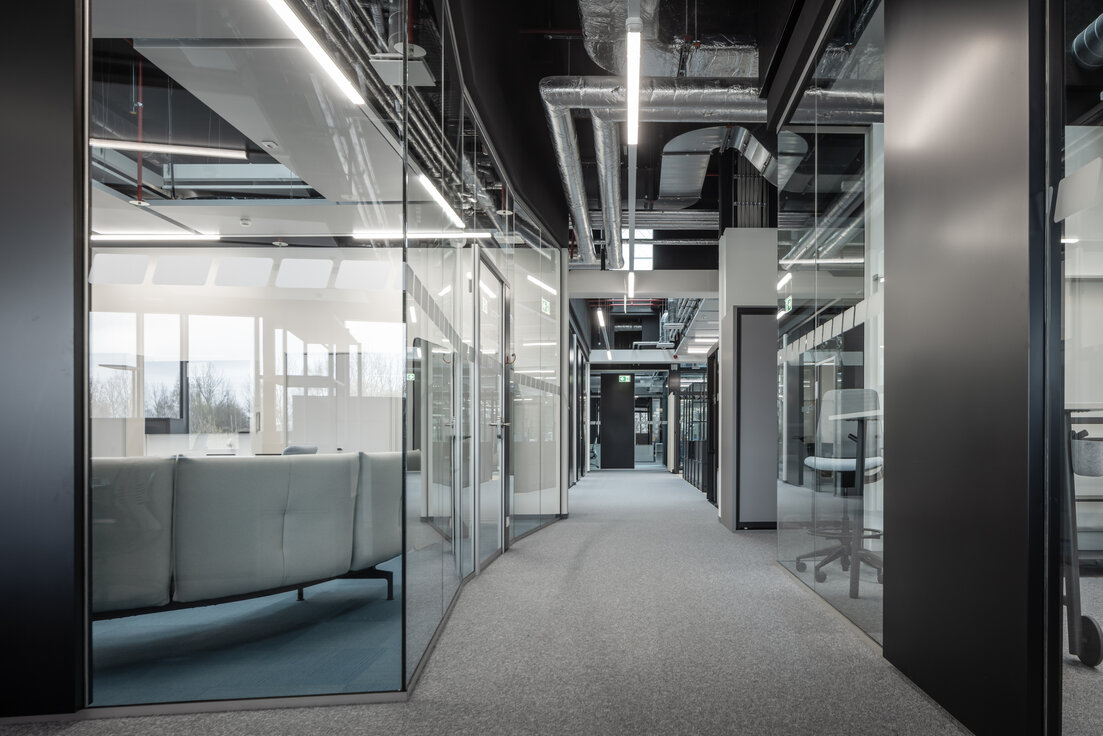 © © www.Lindner-Group.com Flurbereich im Neubau von Endress+Hauser in Waldheim mit schwarzen Lindner Glastrennwänden im Industrial Style, transparente Büro- und Besprechungsbereiche | © © www.Lindner-Group.com