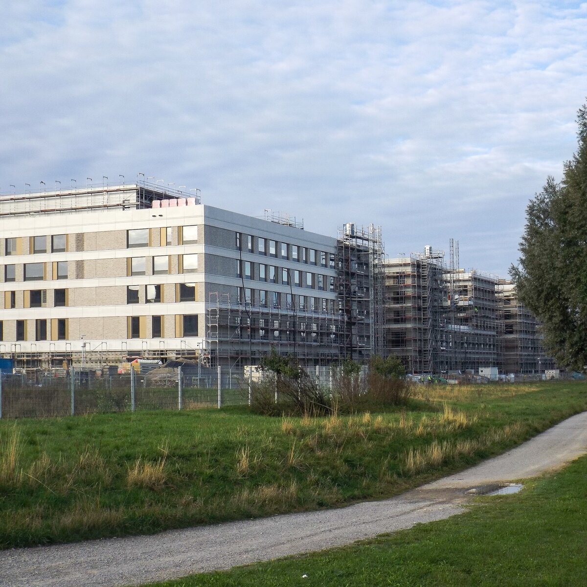 Außenansicht des im Bau befindlichen Flugfeldklinikums Böblingen mit teilweisem Gerüst an der Fassade und Grünflächen im Vordergrund. | © © www.Lindner-Group.com