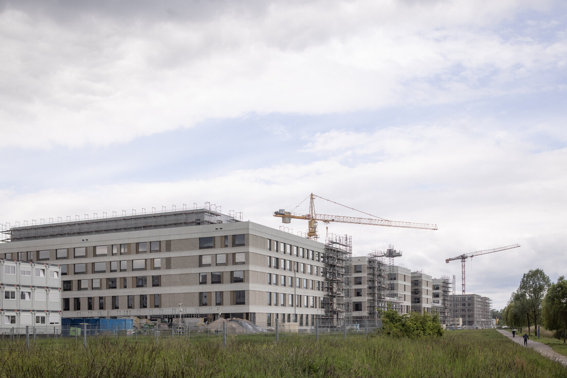 Außenansicht des im Bau befindlichen Flugfeldklinikums Böblingen mit teilweisem Gerüst an der Fassade und Grünflächen im Vordergrund. | © © www.Lindner-Group.com