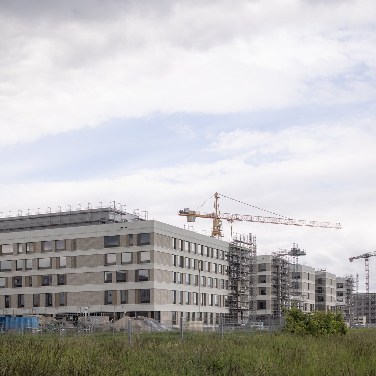 Außenansicht des im Bau befindlichen Flugfeldklinikums Böblingen mit teilweisem Gerüst an der Fassade und Grünflächen im Vordergrund. | © © www.Lindner-Group.com