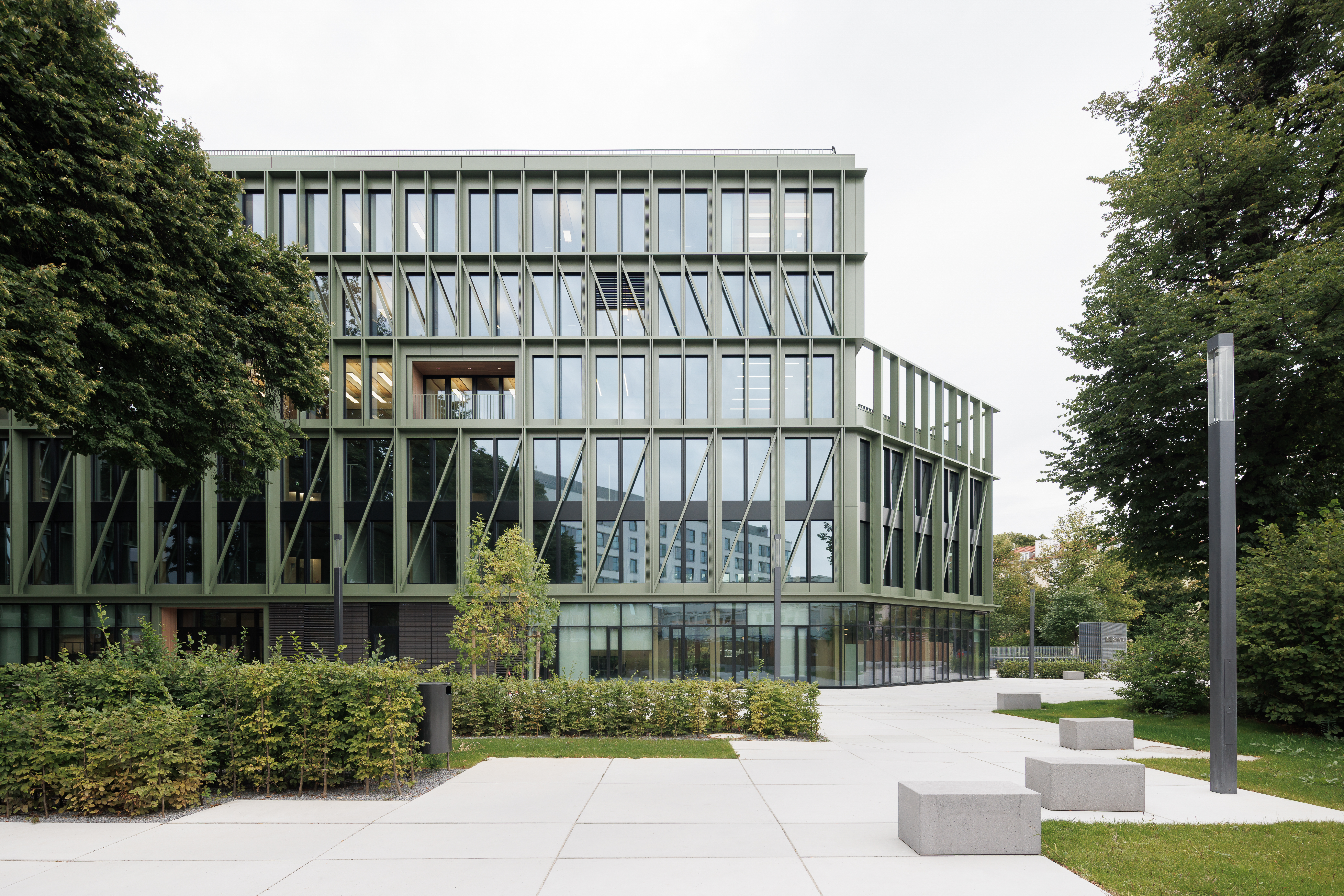 Außenansicht des Interhyp-Büros in München mit gläserner Fassade und Grünfläche; im Inneren verbaute Lindner Raum-in-Raum-Systeme. | © © Nikolay Kazakov