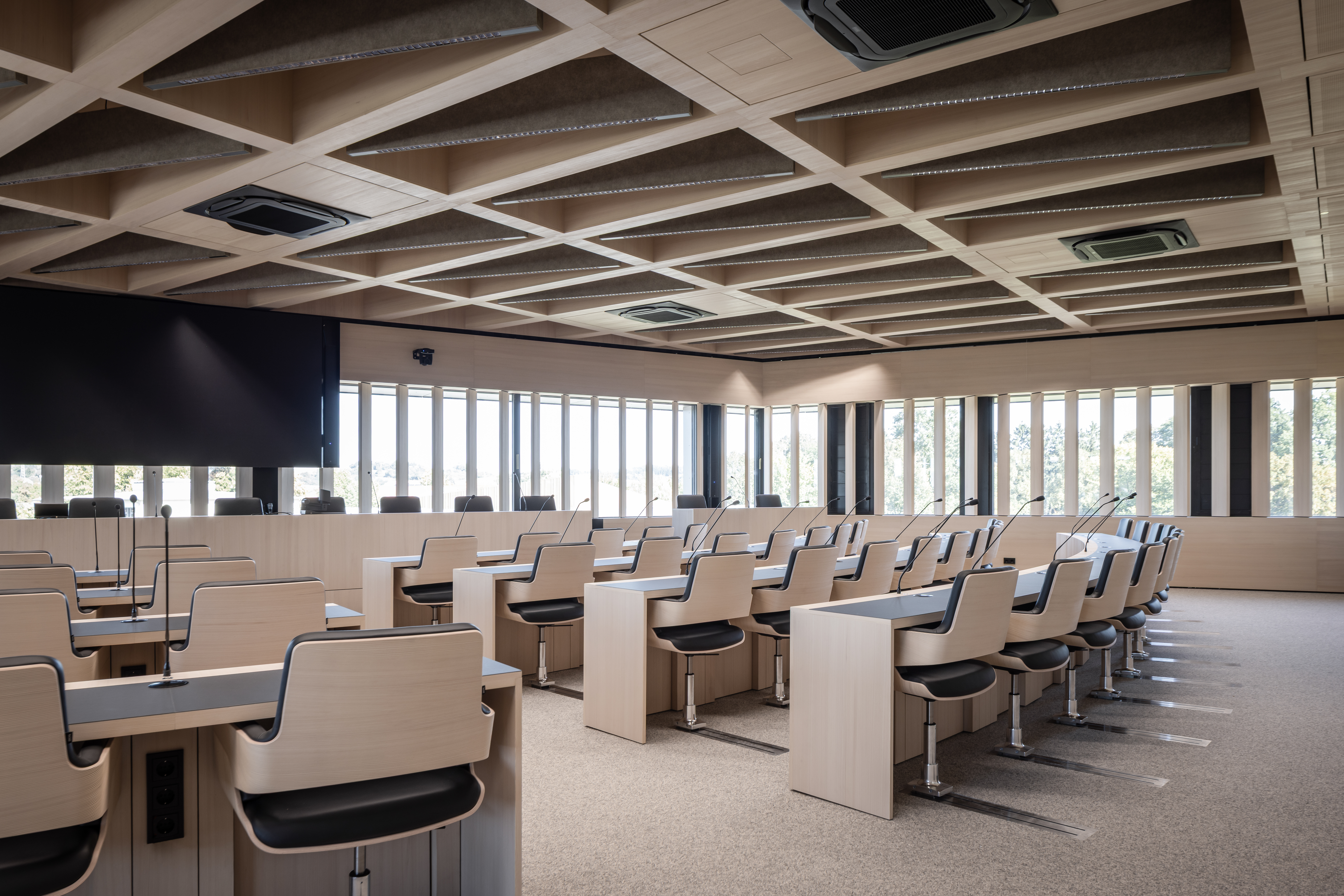 Moderner Sitzungssaal im Landratsamt Landshut mit hellem Holz, maßgefertigten Tischen und hochwertigem Innenausbau von Lindner Group | © © www.Lindner-Group.com