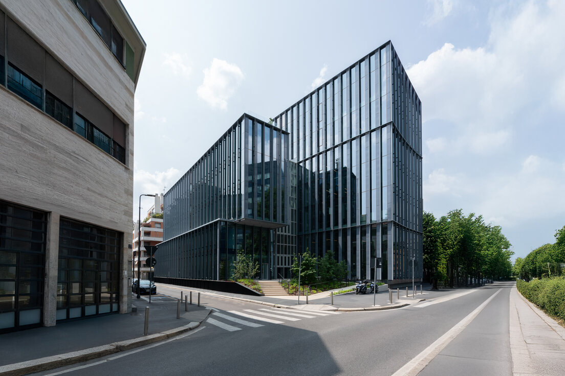 Außenansicht des Bürogebäudes Lybra in Mailand mit markanter Glasfassade an der Via Confalonieri 29 und kreuzender Straße. | © © Paolo Riolzi studio