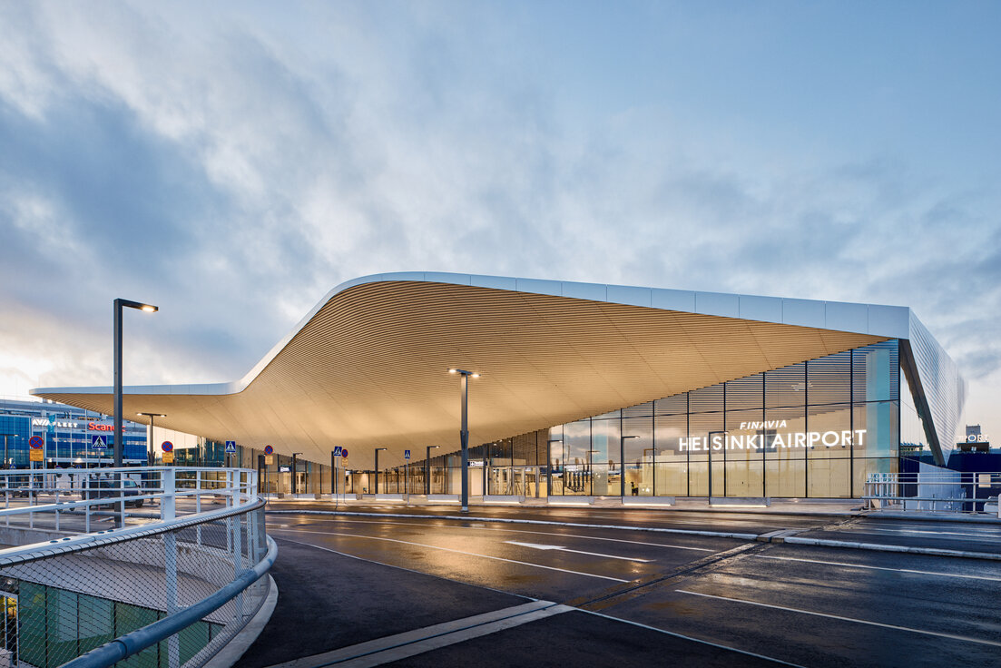 Exterior view of Terminal 2 at Helsinki-Vantaa Airport with curved roof, glass façade and access road | © © Tuomas Uusheimo
