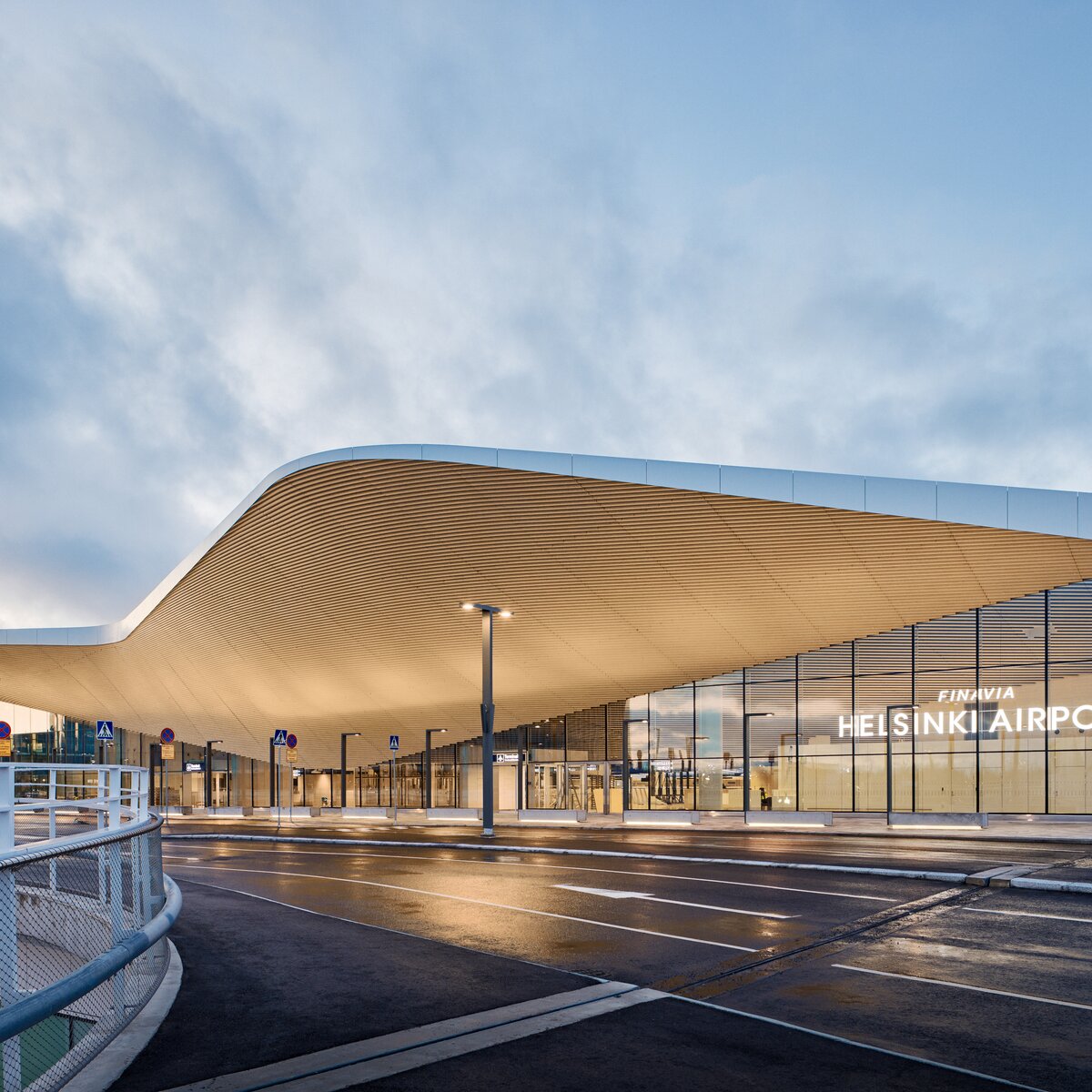 Exterior view of Terminal 2 at Helsinki-Vantaa Airport with curved roof, glass façade and access road | © © Tuomas Uusheimo