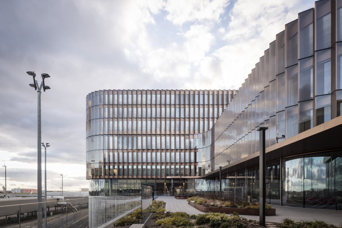 © © www.Lindner-Group.com Skypark Business Center Findel Luxemburg mit kupferfarbener Fassade, Glasfront, Lindner Innenausbauprodukten und Flughafen Luxemburg im Hintergrund | © © www.Lindner-Group.com
