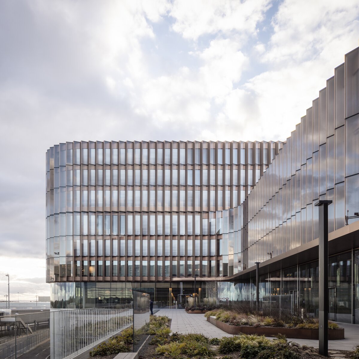 Skypark Business Center Findel Luxemburg mit kupferfarbener Fassade, Glasfront, Lindner Innenausbauprodukten und Flughafen Luxemburg im Hintergrund | © © www.Lindner-Group.com